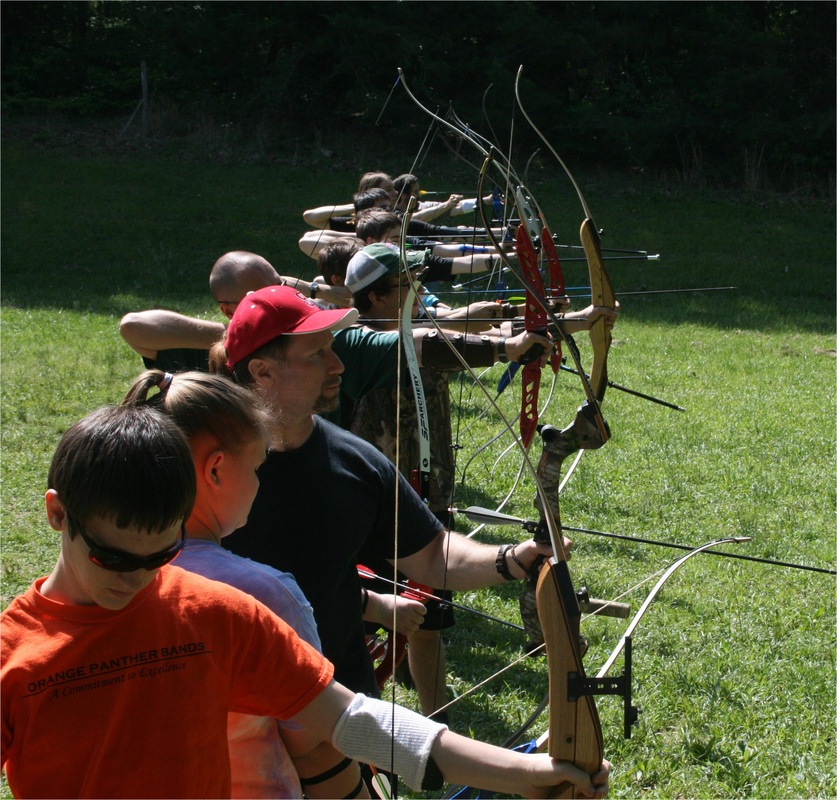 Warm summer day with an assortment of archers shooting on the line. They are shooting both barebow and olympic recurve.