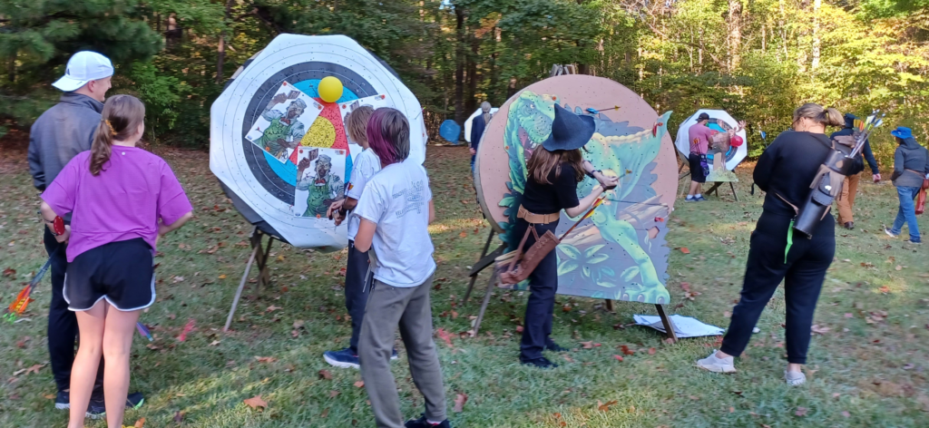 Archers pull their arrows from zombie, T-Rex, and Moose targets
